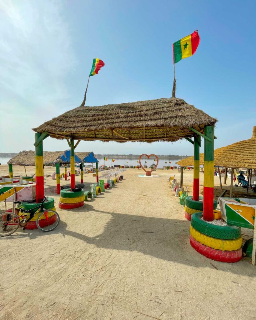 Tradičné senegalské prístrešky a vlajky pri Ružovom jazere Lac Rose počas výletu v Senegale